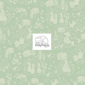 May include: A light green fabric with a repeating pattern of a whimsical forest scene. The design includes trees, rabbits, butterflies, and figures in a garden setting. The KittyFab logo is in the center.