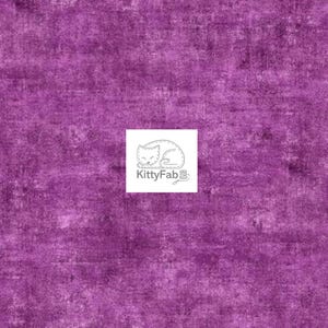 May include: A textured fabric in shades of purple, with a mottled appearance. The fabric has a distressed look, with lighter areas creating a sense of depth. A white square with the KittyFab logo is in the center.
