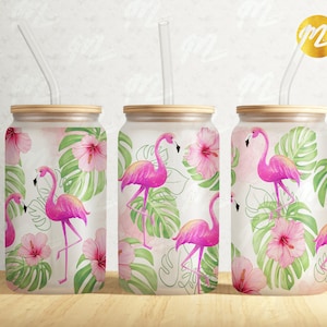 Peut inclure: Trois gobelets réutilisables blancs avec des flamants roses et des feuilles tropicales imprimés dessus. Chaque gobelet est doté d'une paille en plastique transparente.