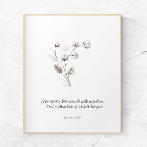 May include: A white background with a framed print of a watercolor illustration of a cotton plant with the quote "She opens her mouth with wisdom. Kind instruction is on her tongue. Proverbs 31:26"