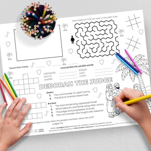 May include: A black and white activity sheet with the text "DEBORAH THE JUDGE" and various puzzles, including a maze, crossword, and word scramble. Colored pencils are scattered around the sheet, with a hand holding a yellow pencil.