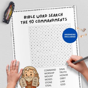 May include: A Bible word search puzzle titled "The 10 Commandments" with a grid of letters. The puzzle includes a list of related words and the text "Answers Included." A pencil is used to circle words. A pencil case with colored pencils is visible.