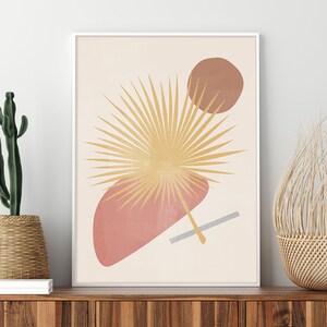 May include: Abstract art print featuring a stylised palm leaf in yellow and gold, with overlapping pink and brown shapes on a cream background.