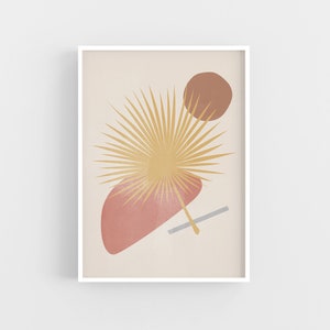 May include: Abstract art print featuring a stylised palm leaf in shades of yellow and gold, a brown circle, and a pink and red shape. The print is framed in a white frame.