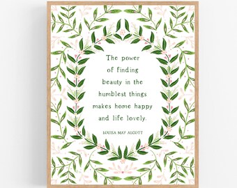 May include: A framed print with a white background and a green floral border. The quote inside the border reads "The power of finding beauty in the humblest things makes home happy and life lovely." The quote is attributed to Louisa May Alcott.
