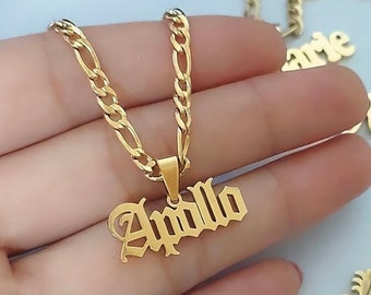 Puede incluir: Collar de cadena dorada con un colgante que dice "Apollo" en una fuente gótica.