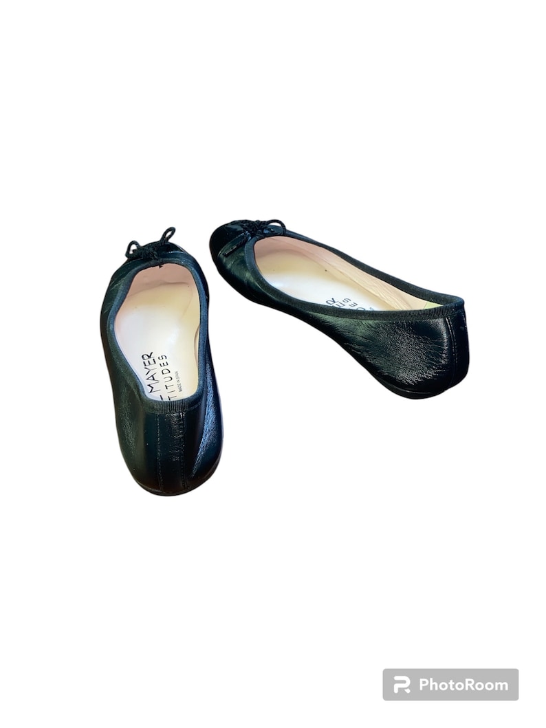 May include: Pair of black leather ballet flats with a small bow detail on the toe. The flats are made by Mayer  &  Stid, and are made in Italy.