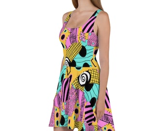May include: A sleeveless dress with a colorful patchwork design featuring pink, yellow, blue, and black. The dress has a fitted bodice and a flared skirt.
