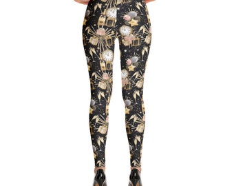 Puede incluir: Leggings negros con un estampado dorado y blanco de copas de champán, relojes y confeti. El estampado es un patrón repetitivo.