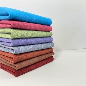 May include: A stack of eight different colored felt fabric squares. The colors are blue, red, green, purple, gray, brown, and burgundy.