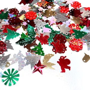 May include: Assortment of colorful Christmas-themed sequins in various shapes, including stars, trees, snowflakes, and bells. The sequins are made of shiny, metallic material and are perfect for crafting and decorating.