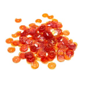 May include: A pile of orange iridescent sequins. The sequins are scattered on a white background.