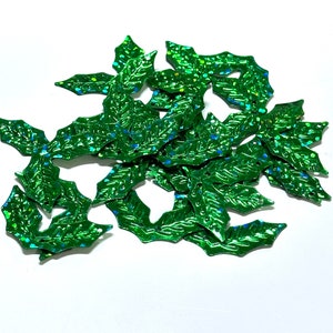 May include: A pile of green glitter holly leaves, perfect for crafting or decorating.