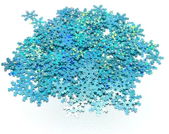 May include: A pile of iridescent blue snowflake-shaped glitter. The glitter is perfect for adding a touch of sparkle to crafts, decorations, and more.