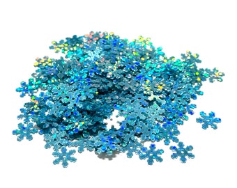 May include: A pile of iridescent blue snowflake-shaped glitter. The glitter is perfect for adding a touch of sparkle to crafts, cards, and other projects.