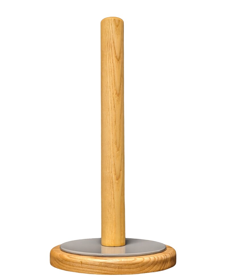May include: A wooden paper towel holder with a gray metal base. The holder is made of natural wood with a light brown finish.