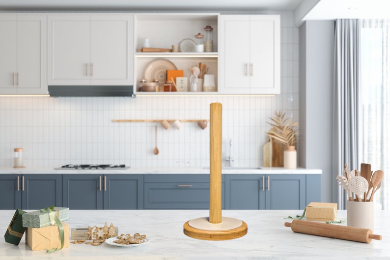 May include: A wooden paper towel holder with a white base. The holder is standing on a white countertop in a kitchen setting.