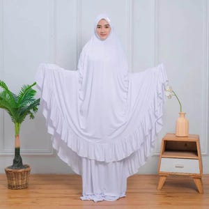 May include: White prayer dress with a ruffled hem and long sleeves. The dress is made of a soft, comfortable fabric and is perfect for prayer or meditation.