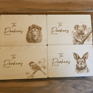 May include: Four wooden coasters with laser-engraved images of a lion, koala, bird, and rabbit. Each coaster features the text "The Parkens EST 2007".