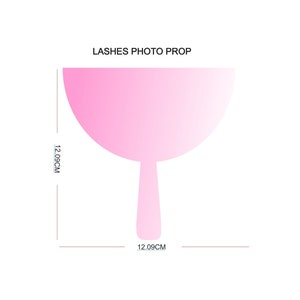 May include: Pink plastic photo prop shaped like a fan with a handle. The prop is 12.09 cm wide and 12.09 cm tall.  LASHES PHOTO PROP is written at the top of the image.