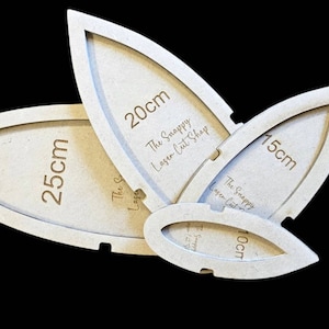 May include: Three wooden sewing templates in the shape of a leaf, with measurements of 10 cm, 15 cm, and 20 cm. The templates are made by The Snappy Laser Cut Shop.