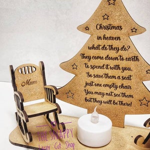 Puede incluir: Adorno de &aacute;rbol de Navidad de madera con una mecedora y una vela encendida. El &aacute;rbol tiene el texto "Navidad en el cielo, &iquest;qu&eacute; hacen? Bajan a la tierra para pasarlo contigo. As&iacute; que res&eacute;rvales un asiento, solo una silla vac&iacute;a. Puede que no los veas, pero estar&aacute;n ah&iacute;!" La mecedora tiene la palabra "Mam&aacute;" en la parte posterior.