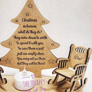 Puede incluir: Adorno de &aacute;rbol de Navidad de madera con dos mecedoras, una etiquetada como "Pap&aacute;". El &aacute;rbol tiene una cita sobre los seres queridos en el cielo que bajan a la tierra para pasar la Navidad contigo. El adorno incluye una peque&ntilde;a luz de t&eacute; LED.