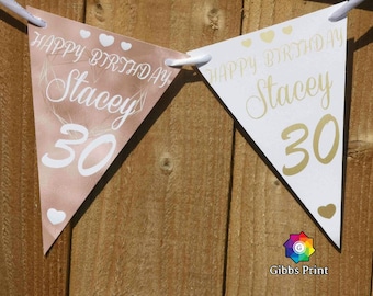May include: A pink and white triangle banner with gold lettering that reads "Happy Birthday Stacey 30".