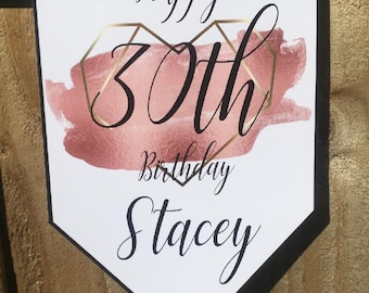 May include: A white banner with black trim and black string for hanging. The banner has a pink and gold geometric heart design with the text "Happy 30th Birthday Stacey".