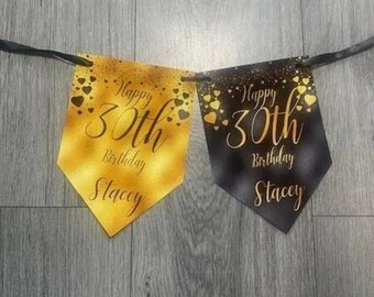 May include: A black and gold banner with the text "Happy 30th Birthday Stacey" on each flag. The flags are decorated with gold hearts.