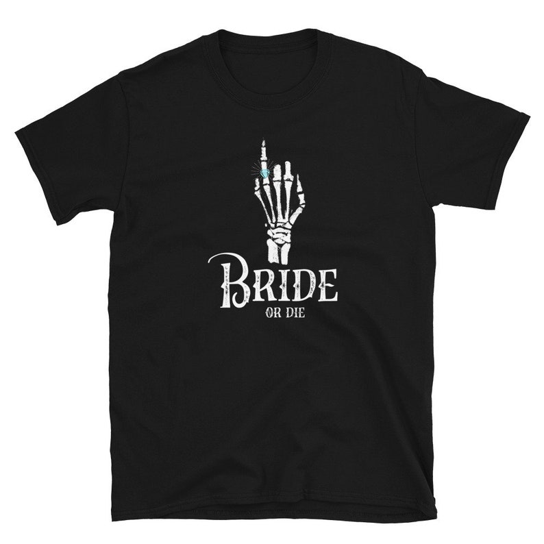 May include: Black t-shirt featuring a white skeleton hand wearing a ring and the text "Bride or Die".