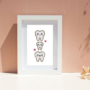 Peut inclure: Un cadre blanc avec un fond blanc et trois dents de dessin animé avec des visages souriants. Les dents sont empilées les unes sur les autres, la plus grande en haut et la plus petite en bas. Il y a deux petits cœurs rouges de chaque côté des dents.