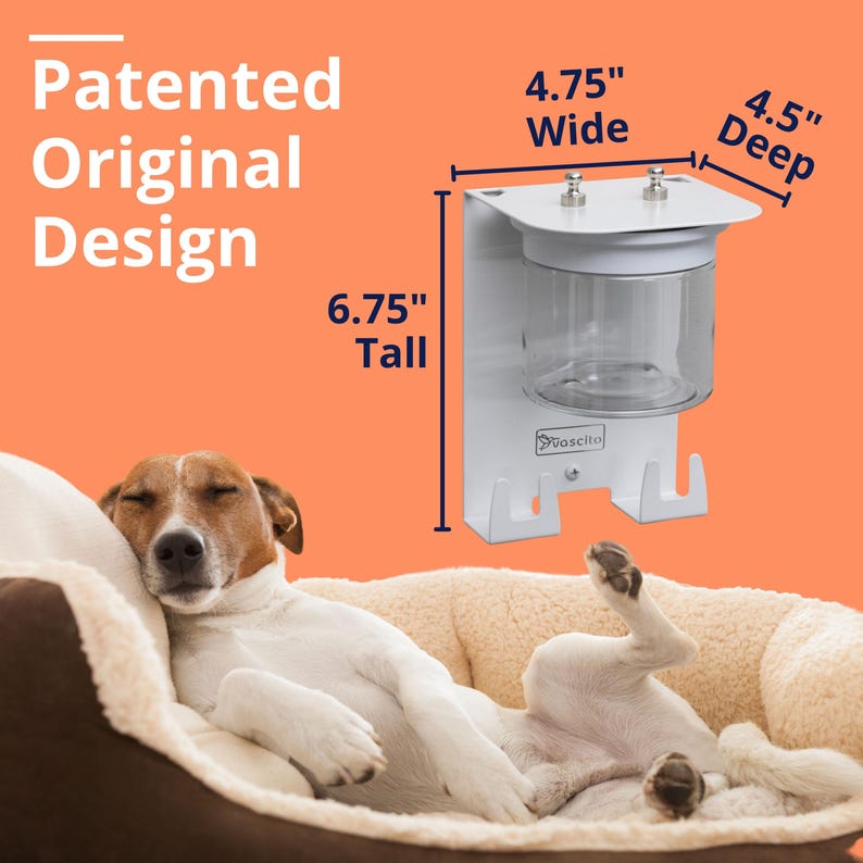 Puede incluir: Un organizador de pared blanco para mascotas con un recipiente cil&iacute;ndrico transparente y dos ganchos. La unidad mide 17,15 cm de alto, 12,07 cm de ancho y 11,43 cm de profundidad. El texto Patented Original Design y Vascito es visible.