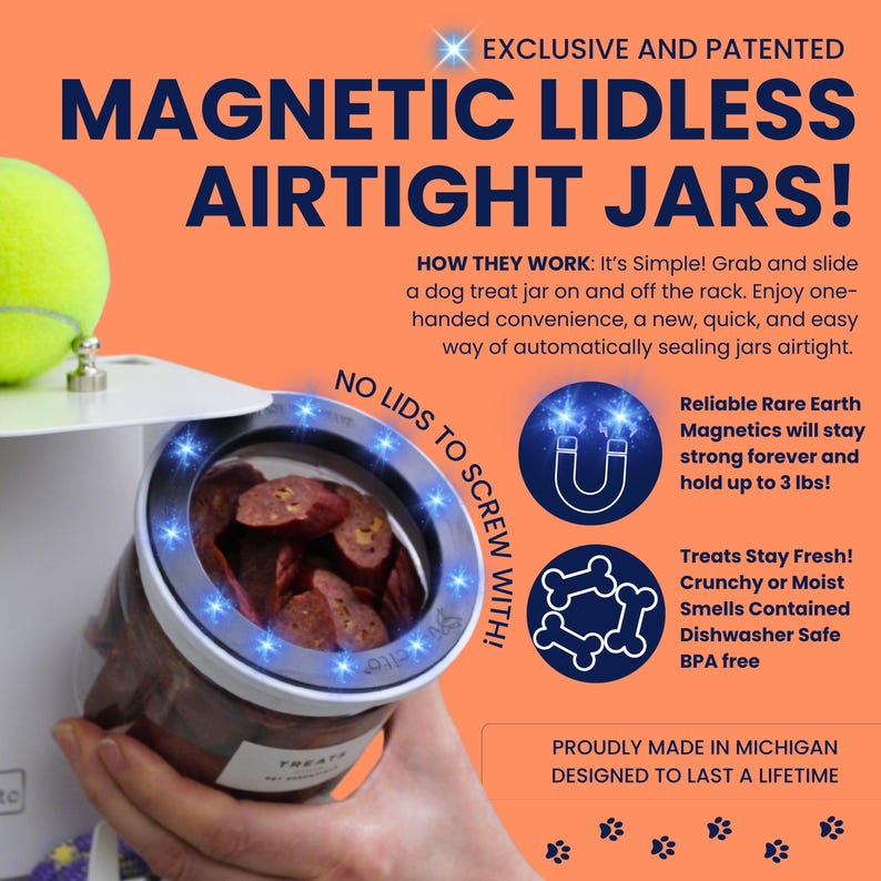 Puede incluir: Un sistema de tarros magn&eacute;ticos herm&eacute;ticos sin tapa para premios de perro con un soporte blanco y un recipiente transparente. El texto incluye EXCLUSIVE AND PATENTED MAGNETIC LIDLESS AIRTIGHT JARS y soporta hasta 1,36 kg de peso.
