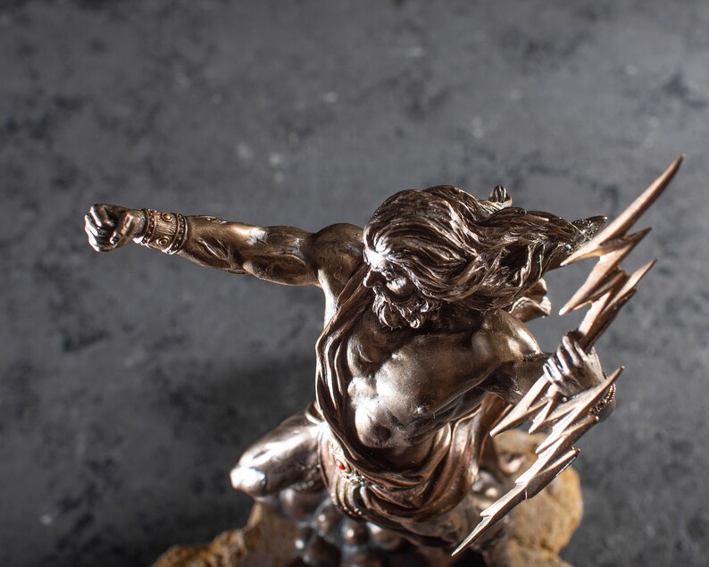 K&ouml;nnte beinhalten: Eine Bronzestatue eines griechischen Gottes, der einen Blitz h&auml;lt. Die Statue ist detailliert und realistisch, mit einem muskul&ouml;sen K&ouml;rperbau und wallendem Haar. Der Gott ist in einer dramatischen Pose dargestellt, mit erhobenem Arm und hoch gehaltenem Blitz.