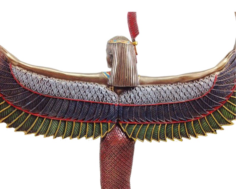 May include: A bronze statue of the Egyptian goddess Isis with outstretched wings. The wings are detailed with green, gold, and blue feathers. The goddess is wearing a red and gold dress and a headdress with a red feather.