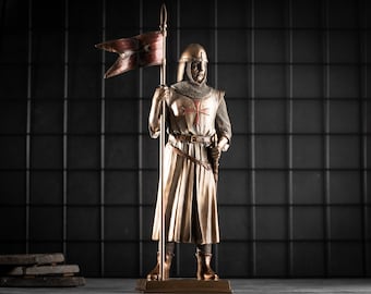 May include: A bronze statue of a knight in armor holding a spear and a red and white flag with a cross. The knight is wearing a chainmail tunic and a white robe with a red cross on the chest. The statue is standing on a black base.