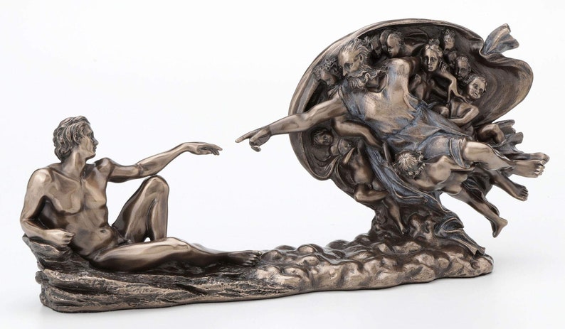 May include: A bronze-toned sculpture depicting the Creation of Adam, featuring a reclining figure reaching toward a bearded figure surrounded by cherubs. The detailed metallic finish highlights the muscular forms and flowing drapery of the figures.