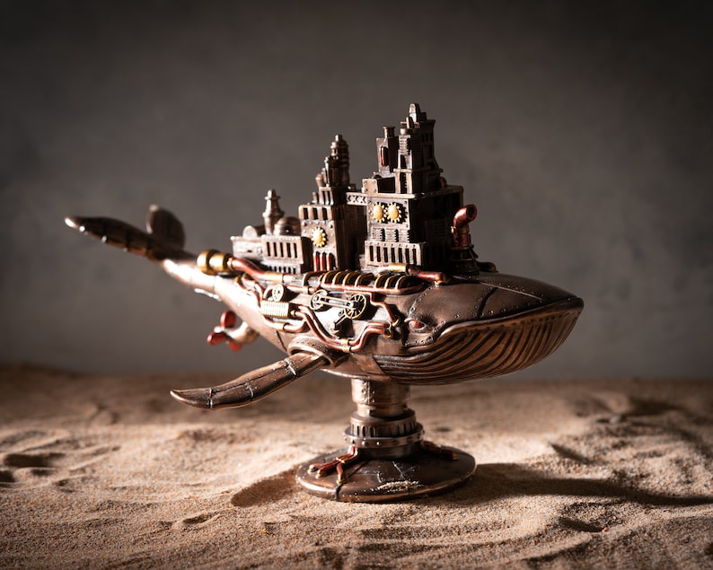 Op de afbeelding: Een steampunk-walfiguur met ingewikkelde details en een bronzen afwerking. De walvis draagt een miniatuurstad op zijn rug, met zichtbare tandwielen en pijpen.