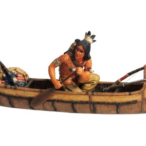 May include: A hand-painted figurine of a Native American man paddling a canoe. The canoe is decorated with brown and tan woven patterns and has a bear paw print on the side. The man is wearing a feathered headdress and a red and white beaded necklace. He is holding a paddle in his right hand and a bow and arrow in his left hand.