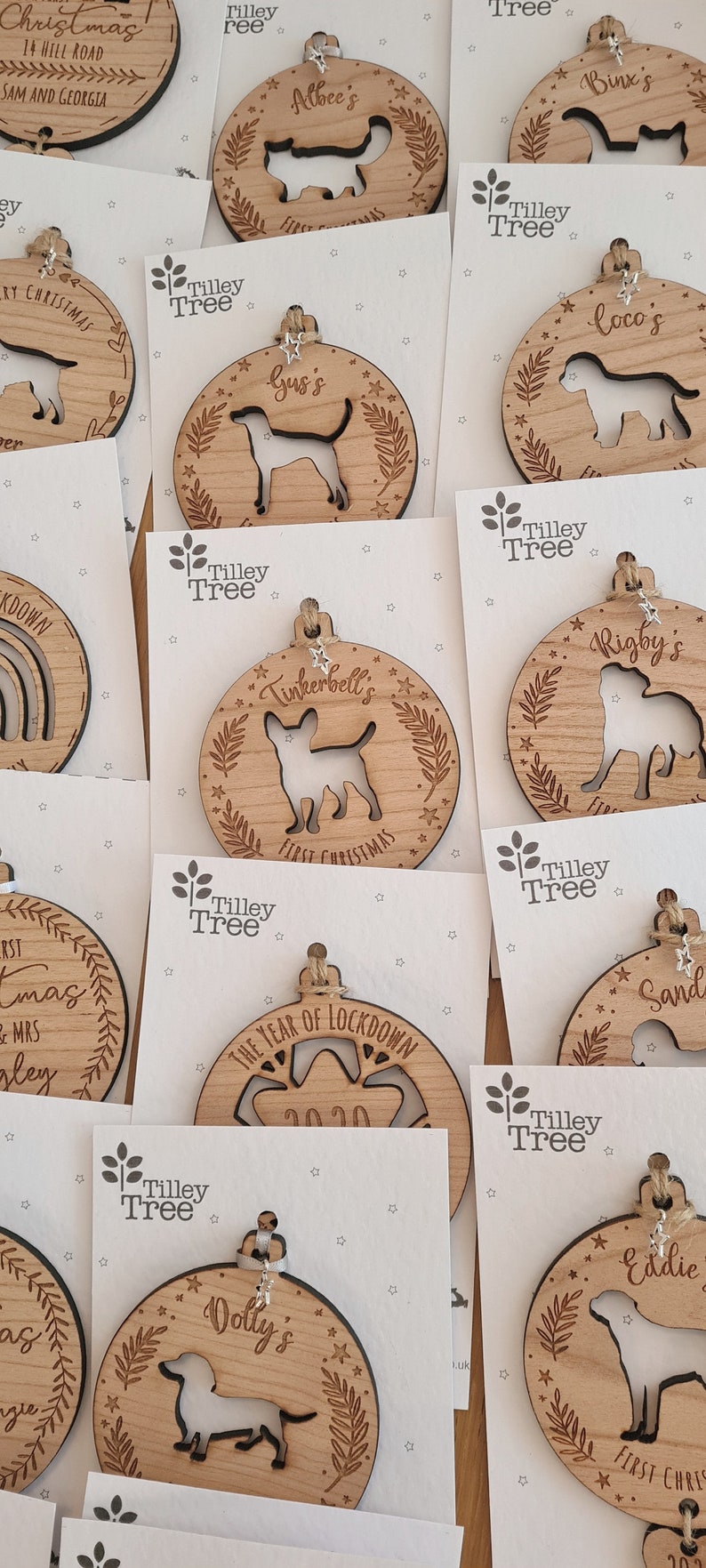 May include: A collection of personalized wooden Christmas ornaments featuring various dog breeds, names, and the year 2020. The ornaments are decorated with stars and leaves.