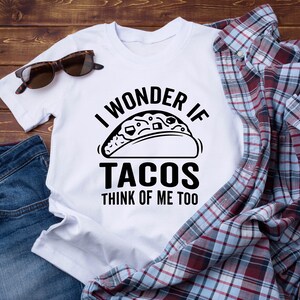 May include: White t-shirt with black text that reads "I wonder if tacos think of me too". The text is accompanied by a black and white illustration of a taco.