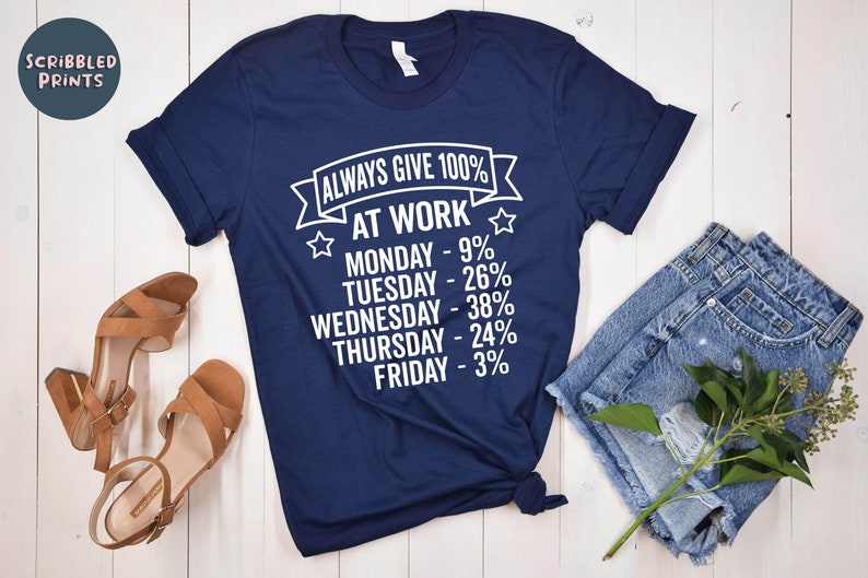 May include: A navy blue t-shirt with white text that reads "Always Give 100% At Work" and lists the days of the week with a percentage next to each day. The percentages decrease as the week goes on, with Monday at 9% and Friday at 3%.