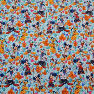 Puede incluir: Una tela azul con un patr&oacute;n repetido de Mickey Mouse, Donald Duck y Pluto. Mickey Mouse est&aacute; vestido de chef y sostiene una esp&aacute;tula. Donald Duck lleva un gorro de cocinero y sostiene un rodillo. Pluto lleva un gorro de cocinero y sostiene un batidor. El fondo es azul claro con un patr&oacute;n de orejas de Mickey Mouse, remolinos y palos.