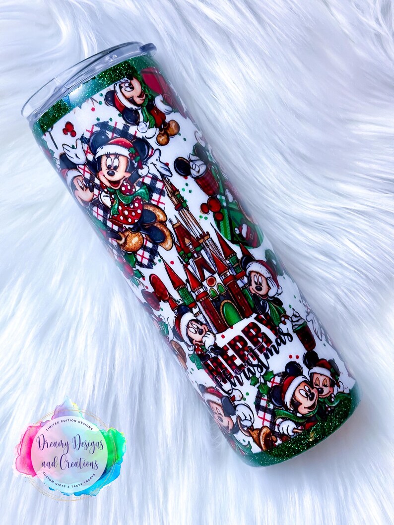 Pode incluir: Um copo verde e branco com um design de Natal com o Mickey Mouse e o texto "Feliz Natal".