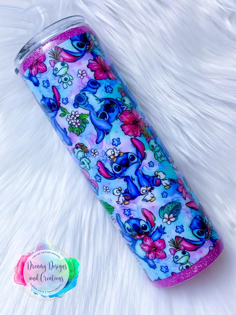 May include: A blue and pink stainless steel tumbler with a glitter rim. The tumbler features a repeating pattern of Stitch from Lilo & Stitch, flowers, and tropical leaves.