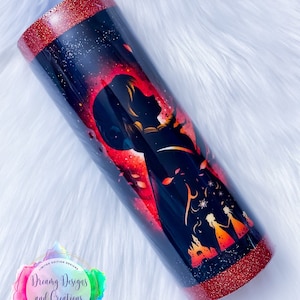 Op de afbeelding: Een rode en zwarte glitterbeker met een silhouet van een vrouw en een kasteel. De beker heeft een rode glitterrand en -basis. De tekst "Dreamy Designs and Creations" staat op de beker.