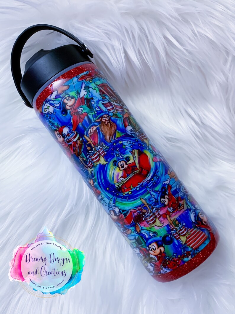 May include: A red glitter tumbler with a black lid and handle. The tumbler features a colorful design of Mickey Mouse and other Disney characters. The text "Dreamy Designs and Creations" is printed on the tumbler.
