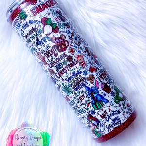 Pu&ograve; includere: Un bicchiere rosso e bianco con un design a tema natalizio. Il bicchiere presenta una variet&agrave; di personaggi e frasi, tra cui Topolino, Stitch e "&Egrave; il periodo pi&ugrave; bello per indossare le orecchie".