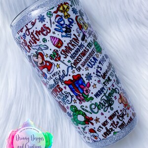 Pu&ograve; includere: Un bicchiere bianco con un bordo di glitter argentato presenta un design a tema natalizio con Topolino, Minnie Mouse e altri personaggi Disney. Il design include il testo "&Egrave; il periodo pi&ugrave; bello dell'anno", "Ho Ho Ho", "Buon Natale" e "Non &egrave; quello che c'&egrave; sotto l'albero che conta".